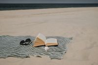 Kaboompics - Open Book on a Beach Towel with Empty Sea View