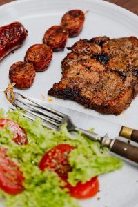 Kaboompics - Close Crop of Grilled Pork Neck and Sausages with Lettuce and Tomato Salad