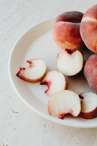 Kaboompics - Sliced Peaches and Whole Nectarines on White Plate, Fruit Background