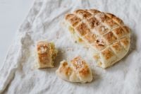 Kaboompics - Torn Slovenian Bread Loaf with Soft Crumb on Linen, Artisan Baking Recipe Visual