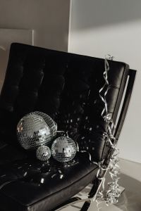 Kaboompics - Three Silver Disco Balls and Curled Streamer on a Black Leather Chair