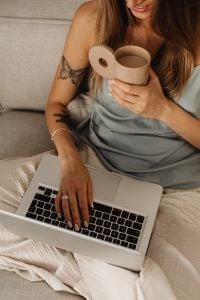 Kaboompics - Woman Smiling over a Coffee Mug with a Laptop in the Foreground