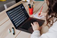 Kaboompics - Woman Typing on Laptop with Text on Screen