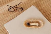 Kaboompics - Eyeglasses Resting beside a Beige Book on a Wooden Desk, Neutral Reading Still Life