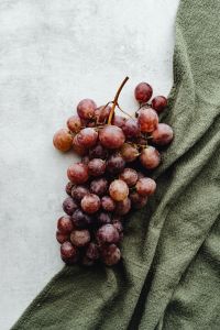 Kaboompics - Red Grapes with Olive Linen and Neutral Background Copy Space