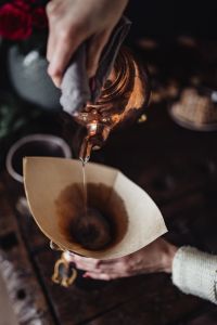 Kaboompics - Close-Up of a Copper Kettle Pouring Water into a Chemex Coffee Filter, Dark Brewing Scene