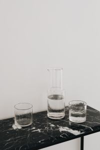 Kaboompics - Glass Carafe and Two Water Glasses on a Marble Console Corner