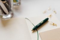 Kaboompics - Close-Up Green Fountain Pen and Gold Paper Clips on Notebook with Soft-Focus Office Background