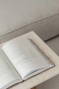 Kaboompics - Reading Book and Beige Sofa on a Travertine Coffee Table