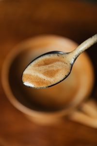 Kaboompics - Spoon Lifting Foamy Coffee from a Ceramic Cup, Close-Up