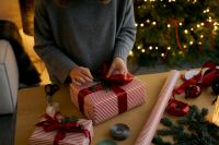 Kaboompics - Tying Red Ribbon on Striped Christmas Gift