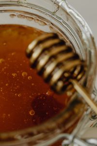 Kaboompics - Shallow Depth of Field Honey Jar and Dipper, Amber Syrup Macro Food Texture