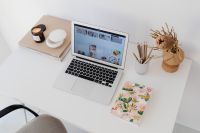 Kaboompics - Overhead Laptop Workspace with Candle, Books and Floral Notebook