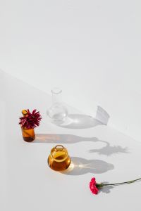 Kaboompics - Single Pink Flower in an Amber Bud Vase with a Second Vessel on White