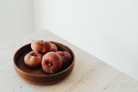 Kaboompics - Wooden Bowl of Peaches with Soft Neutral Background and Copy Space