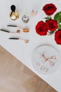 Kaboompics - Red roses, gold rings, perfume brushes and make-up accessories on white marble