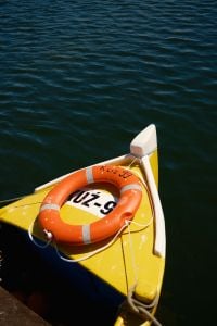 Kaboompics - Yellow Boat With Orange Lifebuoy on Calm Water