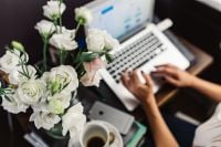 Kaboompics - Woman Working From Home On Laptop With White Flowers