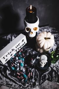 Kaboompics - Overhead Halloween Still Life with Skull Candle, White Pumpkin and Treat Sign