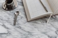 Kaboompics - Chrome Espresso Cup and Pen on Open Planner, Marble Desk Still Life with Copy Space