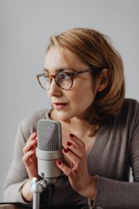 Kaboompics - Glasses-Wearing Woman Speaking Softly beside a Microphone, ASMR Voice Portrait