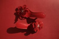 Kaboompics - Red Crochet Flower Sandals Arranged on Red with Dramatic Shadows, Horizontal Flat Lay