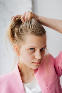 Kaboompics - Close-Up Portrait of a Blonde Woman with Tied-Back Hair and Pink Blazer