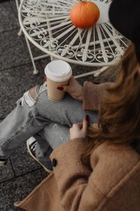 Kaboompics - Overhead View of Woman with Coffee Beside a Small Pumpkin