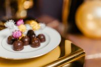 Kaboompics - Chocolate Truffles on White Platter with Decorative Picks and Gold Balloon