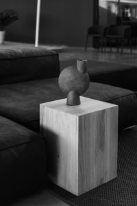 Kaboompics - Black Leather Sofa with a Round Sculptural Floor Vase in a Moody Living Room