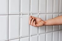Kaboompics - Laying white ceramic tiles in the bathroom