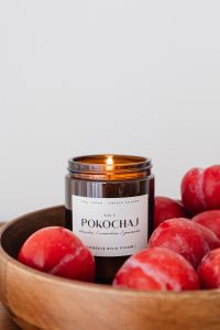 Kaboompics - Close-Up Amber Candle Jar and Plums for Home Fragrance Product Branding