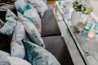Kaboompics - Blue Sofa Cushions beside Turquoise Glassware, Candles and Flowers on Coffee Table