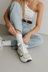 Kaboompics - Close-Up of White Sneaker and Ribbed Sock beneath Cuffed Wide-Leg Jeans, Fashion Detail