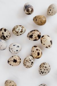 Kaboompics - Extreme Close-Up of Speckled Quail Eggs on White Marble, Seasonal Food Texture