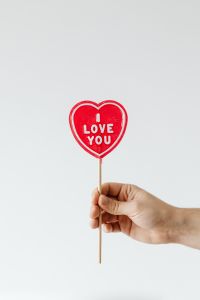 Kaboompics - Hand Holding I Love You Heart Lollipop Against White Background