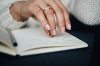 Kaboompics - Woman holding a ring over a notebook