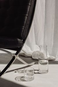Kaboompics - Modern Glassware Display Beside a Black Leather Lounge Chair