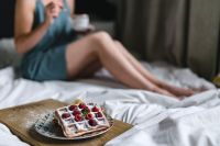 Kaboompics - Woman Enjoying Raspberry Waffles in Bed, Cozy Breakfast Lifestyle