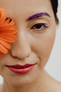 Kaboompics - Close-Up Beauty Portrait with Purple Eyebrow Makeup, Pink Eyeliner and Orange Gerbera