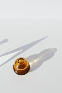 Kaboompics - Overhead View of an Amber Glass Vase and Its Long Shadow on a White Surface