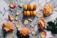 Kaboompics - French Macarons with Peach Roses and Petals on Gray Marble Dessert Flat Lay