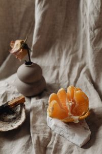 Kaboompics - Mandarin Orange On Folded Linen With Palo Santo And Dried Rose