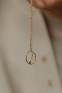 Kaboompics - Gold Pendant Necklace on Tan Silk Shirt Close-Up