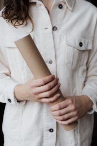Kaboompics - Angled Kraft Cardboard Tube Held by a Person in a White Corduroy Shirt