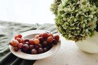 Kaboompics - Red Grapes in a White Ribbed Bowl beside Green Hydrangeas