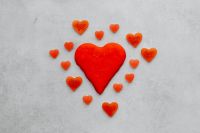 Kaboompics - Large Red Candy Heart Surrounded by Smaller Hearts on Gray Background