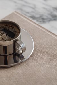 Kaboompics - Chrome Coffee Cup on Books over Arabescato Marble