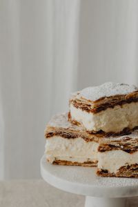 Kaboompics - Close-Up of Layered Napoleonka Cream Cake on a White Stand