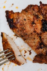 Kaboompics - Macro Detail of Grilled Pork Neck Steak and Cut Slice on White Plate